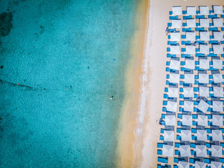 Ornos beach Mykonos island, famous Ornos beach organized with sun beds emerald clear water beach of Ornos in island of Mykonos, Cyclades, Greece.  - obrazy, fototapety, plakaty