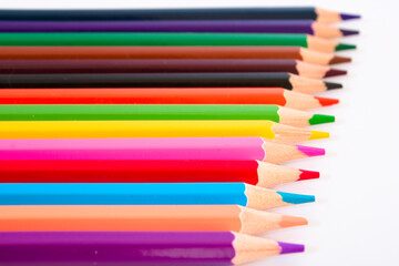 Coloured pencils in a row isolated on white background, selective focus
