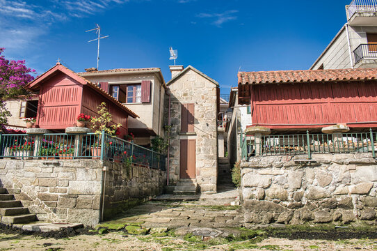 Casas de piedra y tradicionales h&oacute;rreos gallegos pintados de rojo en la villa de Combarro, Espa&ntilde;a