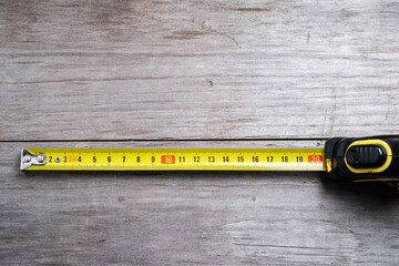 Measuring tape stretched 21 cm on a wooden background. Close-up. Selective focus.