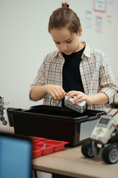 Boy Works on a Fully Functional Programable Robot for His School Robotics Club Project.