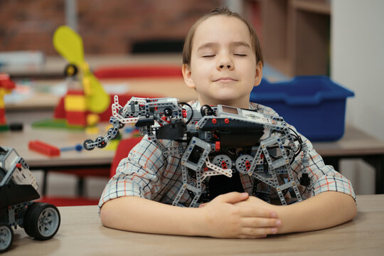 Boy Works on a Fully Functional Programable Robot for His School Robotics Club Project.