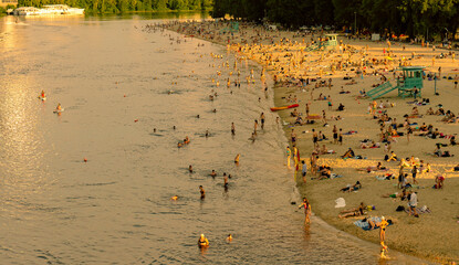 Top view of people on the big beach. Children, men and women relax in the summer near the river in...