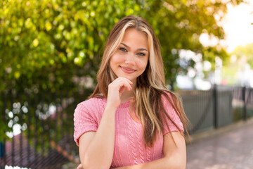 Young pretty blonde girl at outdoors With happy expression