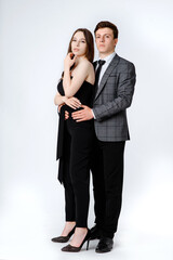 portrait of a young couple in suits on white background.