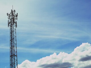 Telephone tower with white clouds in the background.