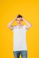 Portrait of a young happy man in white t-shirt smiling and laughing on a yellow