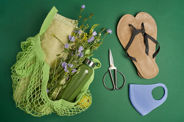 Green string eco bag with fruits, flowers, glass bottle with smoothy, flip-flops shoes, mask,...