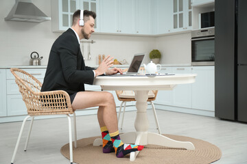 Businessman in underwear pretending to wear formal clothes during video call at home