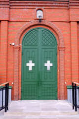 Closed entrance doors to a red brick church