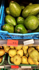 fruits and vegetables on a shelf in a supermarket. avocado and pears on a store shelf.