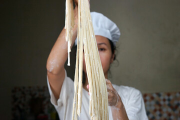 A woman make a hommade noodles.