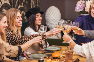 Group of smiling friends making a toast at a dinner party