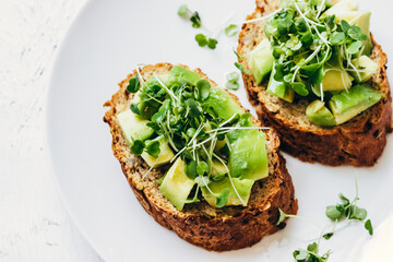 Healthy eating cereal toast with avacado and microgreens