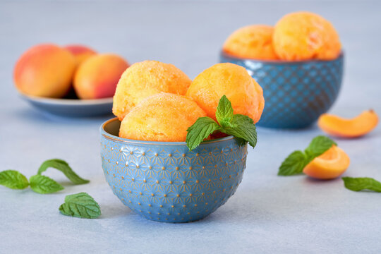 Homemade apricot or peach ice cream , sorbet in bowl with mint leaves. Closeup