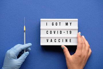 Vaccination motivator concept. Lightbox with text I got my COVID 19 vaccine in hand. Medic hand in...
