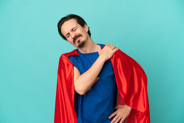 Super Hero caucasian man isolated on blue background suffering from pain in shoulder for having...