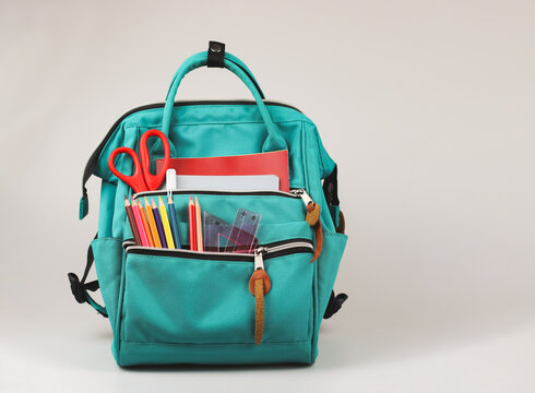 Front view  of backpack with school supplies on white  background with copy space.