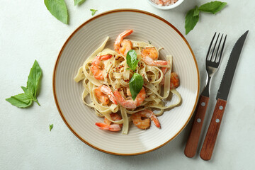 Concept of tasty eating with shrimp pasta on white textured table