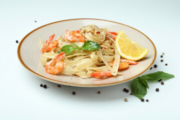 Plate of shrimp pasta on white background