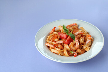 Plate of tasty shrimp pasta on violet background