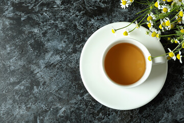 Cup of chamomile tea on black smokey table