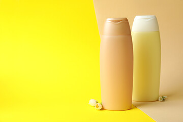 Blank bottles of shampoo on two tone background