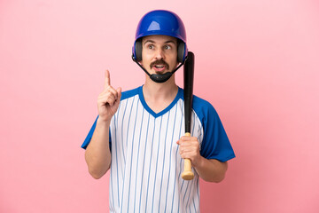 Young caucasian man playing baseball isolated on pink background thinking an idea pointing the finger up