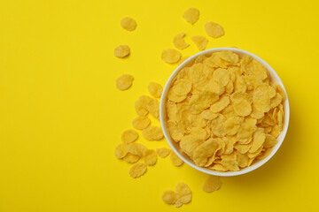 Bowl of corn flakes on yellow background