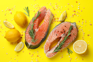 Fresh raw salmon and spices on yellow background