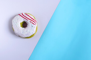 Donuts with pink icing on a colored background. Sweet donut on a two-color divided background of copy space