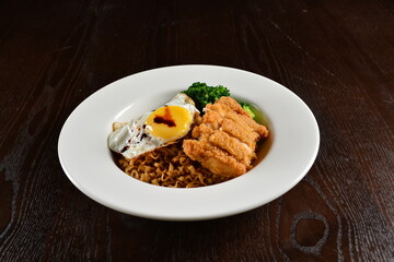 stir fried dry instant noodle mee indo in dark soya sauce with fried egg and crispy chicken chop asian halal menu