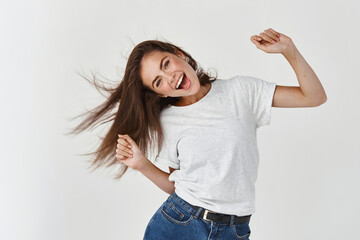 Haircare and beauty concept. Happy young woman dancing and whip healthy shiny hair, having fun,...