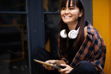 Urban happy woman using digital tablet. Beautiful young woman having video call outdoors.