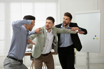 Man interrupting colleagues fight at work in office - obrazy, fototapety, plakaty