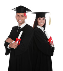 Happy students in academic dresses with diplomas on white background