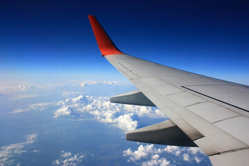 Fototapeta na wymiar Airplane wing in the blue sky