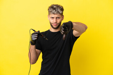 Tattoo artist caucasian man isolated on yellow background showing thumb down with negative expression