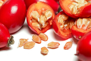 Rosehips ( Rosa Canina fruits ) ,cut in half seeds visible macro closeup detail, isolated on white...