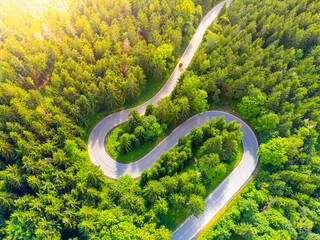 Asphalt road serpentine in the forest. Aerial view from drone.