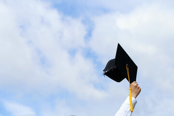 Education. happy students in gowns are celebrating graduation Throwing hands up Graduation Caps in...