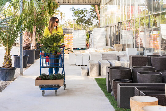 Woman walking with shopping cart in garden center