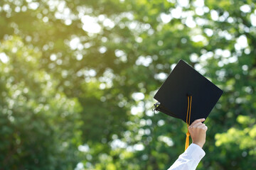 Education. happy students in gowns are celebrating graduation Throwing hands up Graduation Caps in...