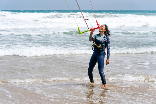 Kitesurfer with kiteboard on sea coast in stormy weather