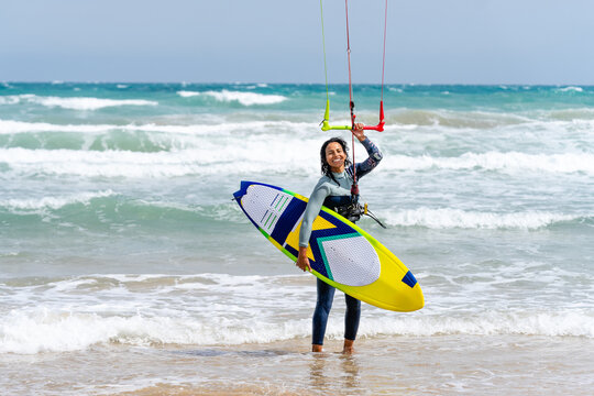 Kitesurfer with kiteboard on sea coast in stormy weather