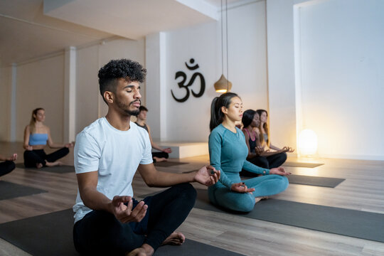 Peaceful multiethnic people meditating together during yoga lesson