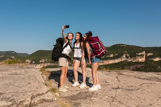 Group of traveling women taking selfie in mountains