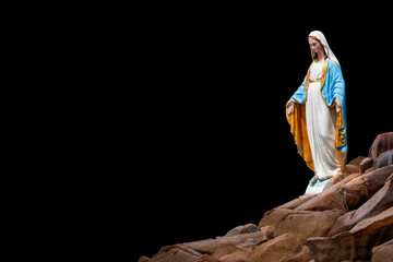 Statues of Holy Women on piles of limestone rocks isolated on black background with clipping path.