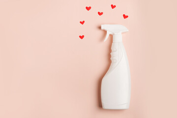 A spray of cleaning fluid on a pink background with hearts. Copy space