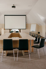 Conference table and a projector in an empty light meeting toom